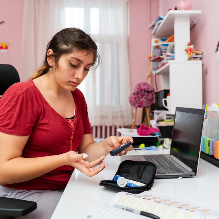 a young girl using a laptop computer sitting on top of a table